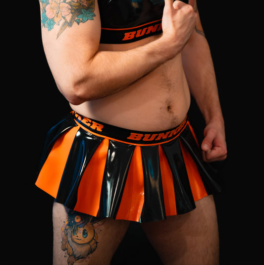 Man wearing a black and orange outfit with 'BUNKER' branding on a black background